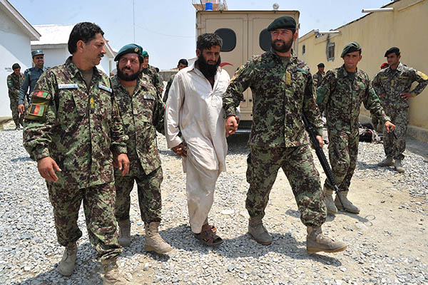 Afghan soldiers escort a captured Taliban fighter in Jalalabad. Noorullah Shirzada—AFP