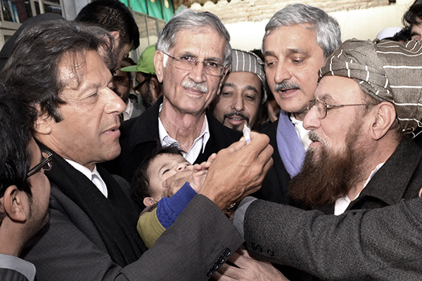 Khan and Haq administer polio drops, Dec. 18. CMH/AFP