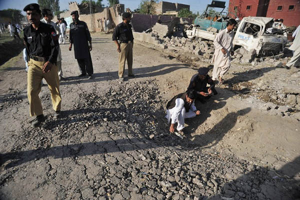 Investigators collect evidence at the site of a blast in Charsadda, 2011. A. Majeed—AFP