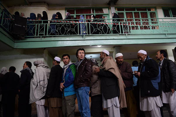 Afghan men and women wait to vote at a polling station in Kabul. Shah Marai—AFP