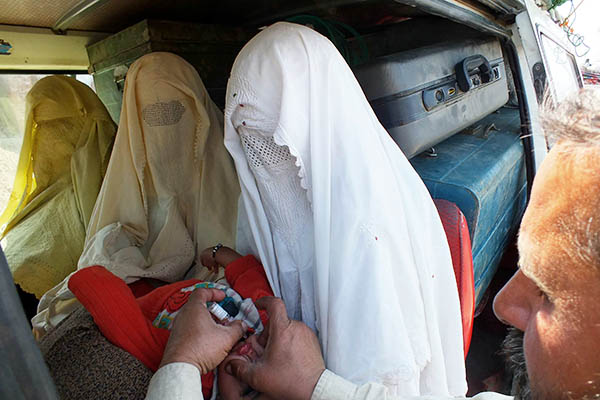 Health workers administer polio vaccinations to IDPs fleeing the North Waziristan military operation. Karim Ullah—AFP