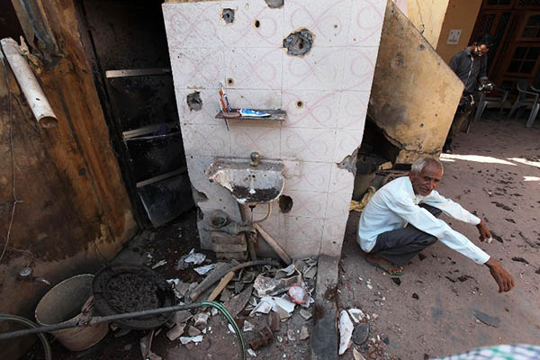 An Indian villager sits in a house damaged by cross-border firing between Indian and Pakistani forces. Rakesh Bakshi—AFP
