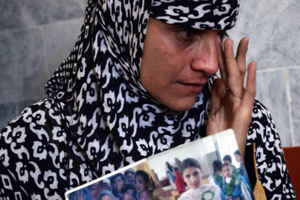 Nadia Khan cries while showing a picture of her sister, who was killed by militants. Hasham Ahmed—AFP