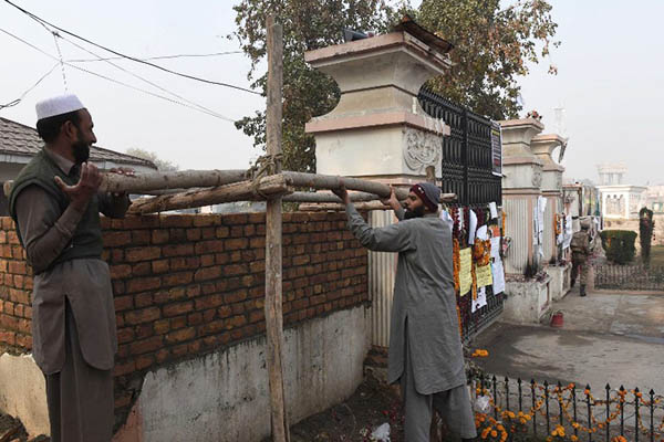 Laborers rebuild the boundary wall of the Army Public School. A. Majeed—AFP