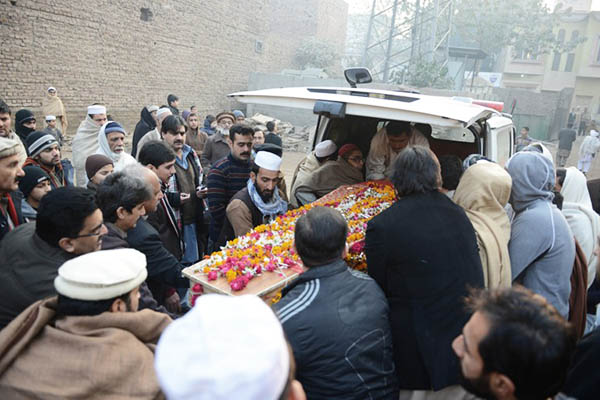 Mourners prepare to bury a coffin in Peshawar. A. Majeed—AFP