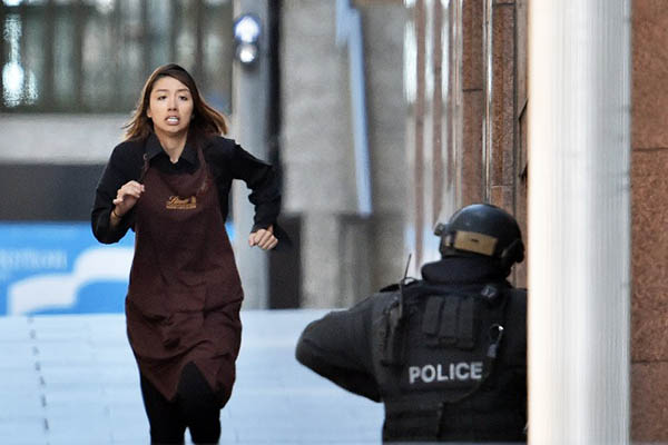 A woman flees the Lindt café currently under siege. Saeed Khan—AFP