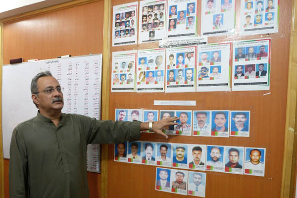 Senior MQM leader Haider Abbas Rizvi shows pictures of party activists believed to have been targeted in extra-judicial executions. Rizwan Tabassum—AFP