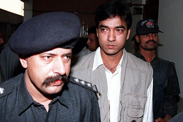 Saulat Mirza escorted by police in Karachi, 1998. Aamir Qureshi—AFP