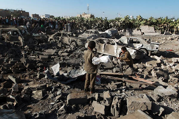 Yemenis examine the site of a Saudi airstrike targeting Houthi rebels near Sanaa Airport on March 26. Mohammed Huwais—AFP