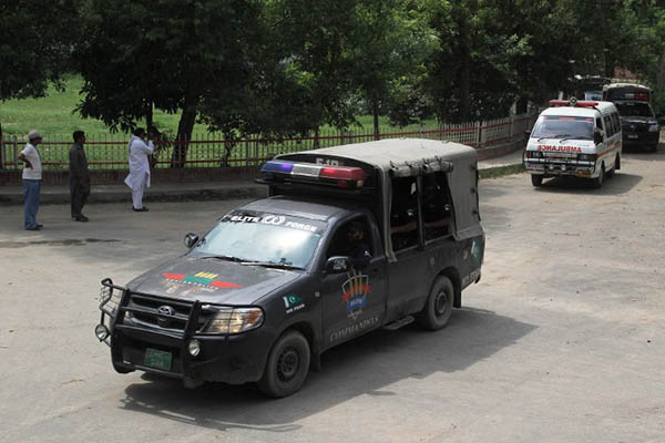 A police convoy transports Malik Ishaq’s body to its burial site. S. S. Mirza—AFP