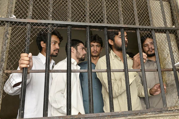 Arrested members of a gang that allegedly abused and blackmailed hundreds of children. Arif Ali—AFP