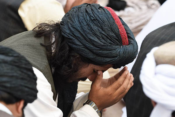 Mourners in Pakistan pray for Taliban chief Mullah Omar after his death. Banaras Khan—AFP