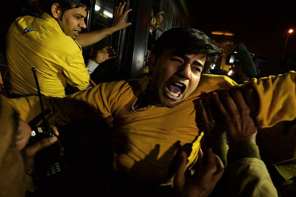 Demonstrators shout slogans after being taken into custody by police officials. Chandan Khanna—AFP