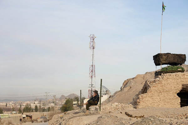An Afghan policeman sits near a private cellphone antenna. Jawed Tanveer—AFP