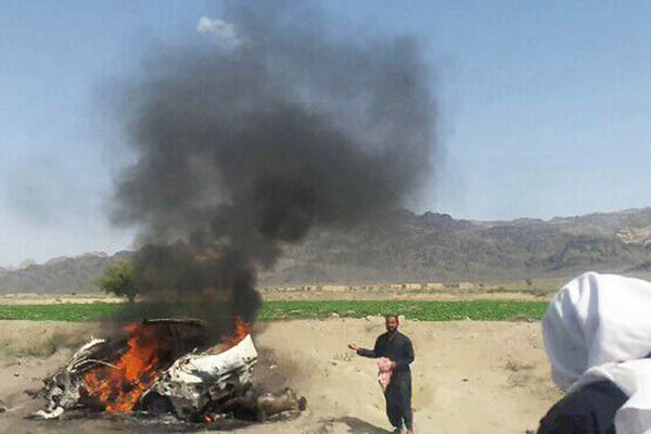 Villagers gather at the wreckage of a vehicle destroyed by drone strikes. AFP