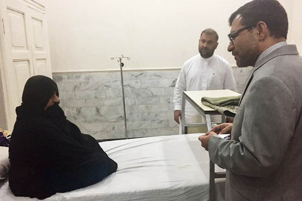 Afghan Consul General in Peshawar Abdul Waheed Poyan speaks with Sharbat Gula at a hospital in Peshawar. A. Majeed—AFP